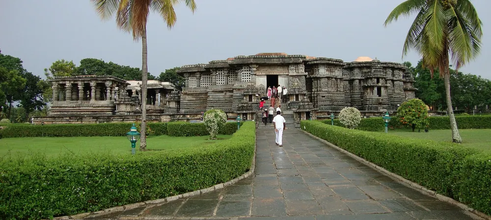 A stone path through gardens leading to the Hoysaleswara Temple at Halebidu